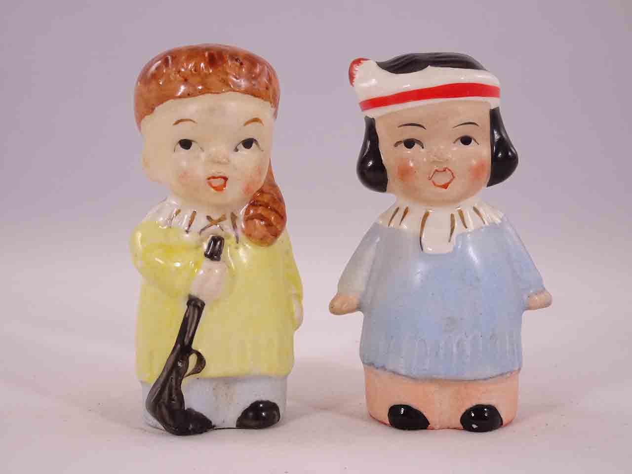48622 Davy Crockett-like boys carrying guns with little Native American Indian girls salt and pepper shakers